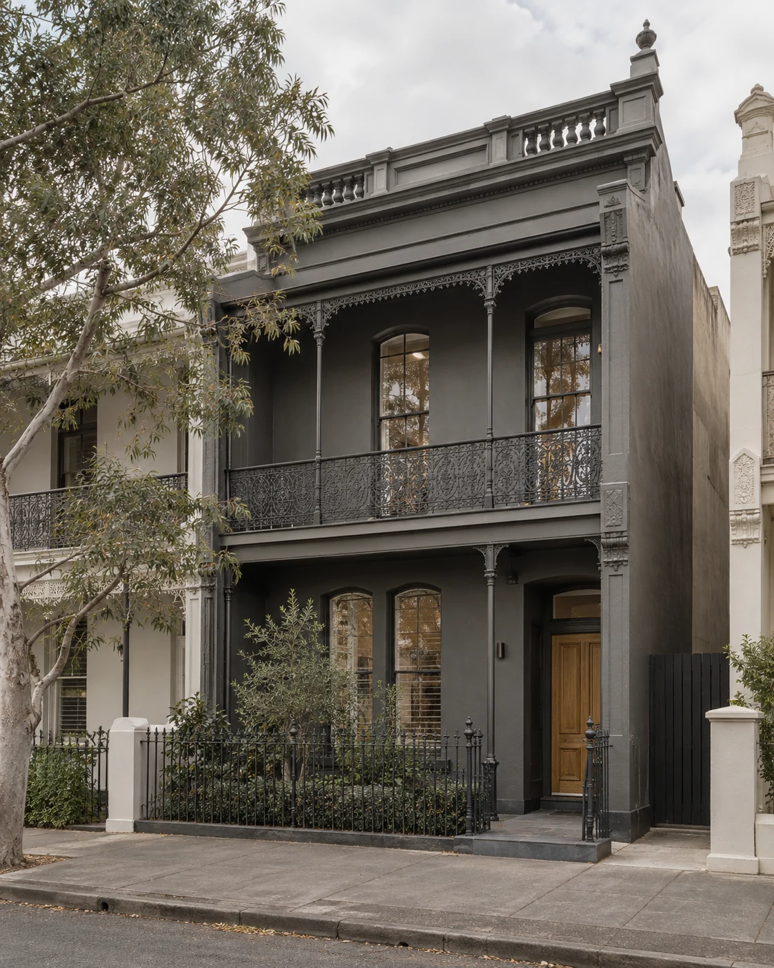 Albert Park terrace renovation with a dark facade, tall windows and a restrained front garden